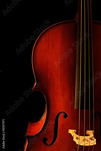 Foto Cello, in close-up with black background.  Natural warm light.
