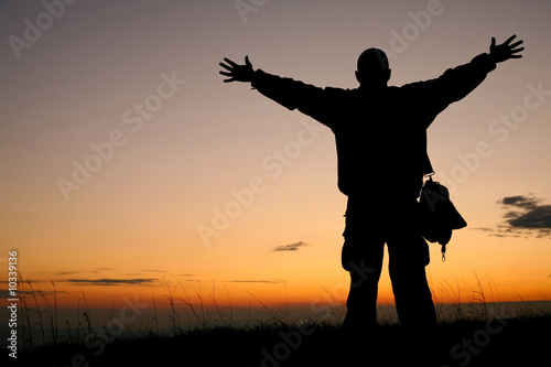 An image of a silhouette of a man on background of sunrise