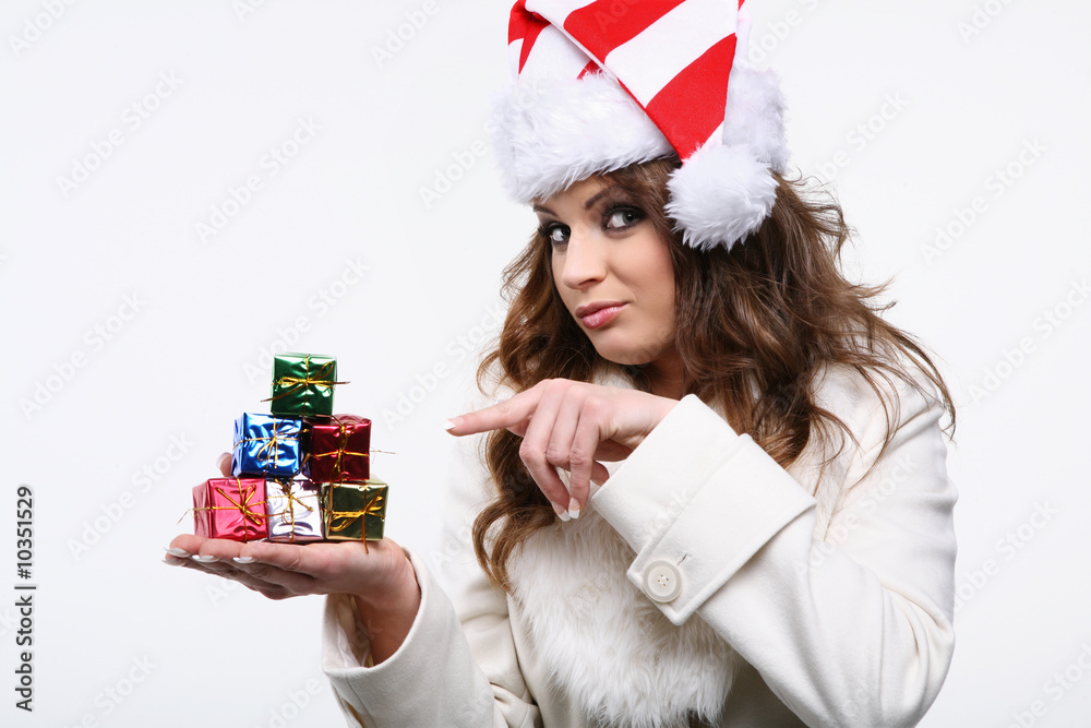 Cute fashion model posing as santa, showing  presents.