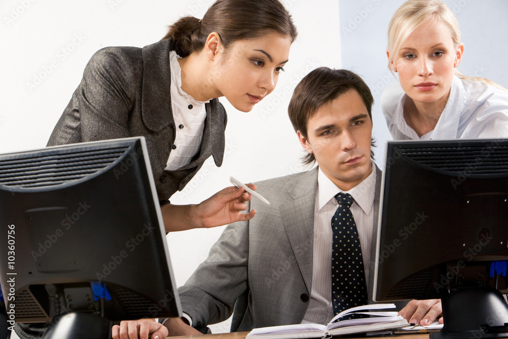 Serious business people looking at computer screen Serious business people looking at computer screen