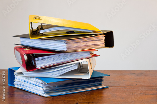 Pile of colored ring binders on wooden desk