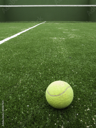Tennis ball on synthetic grass of paddle court. © titelio