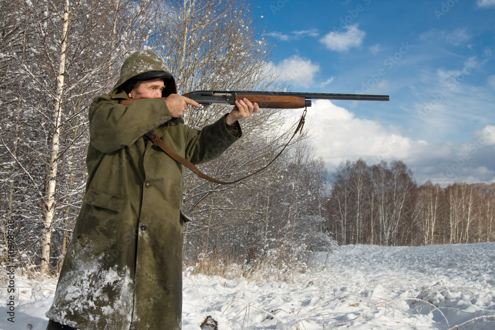 Fototapeta premium The hunter in the winter on a marge of a wood