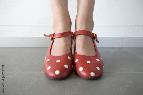 close-up of feet in red shoes with white dots