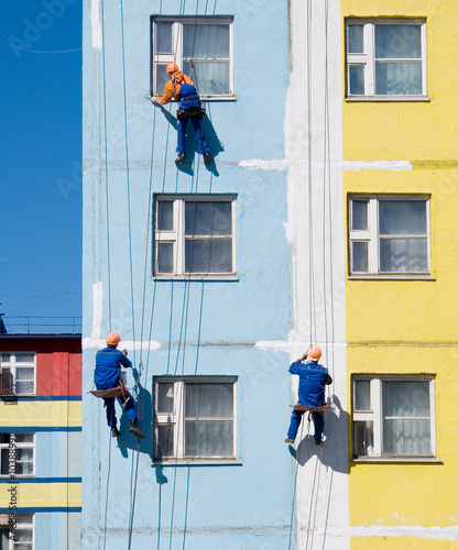 Photo House painters paint the facade of building