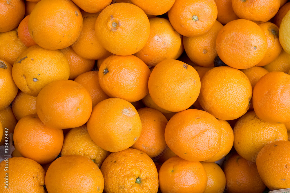A background of fresh oranges in an outdoor market A background of fresh oranges in an outdoor market