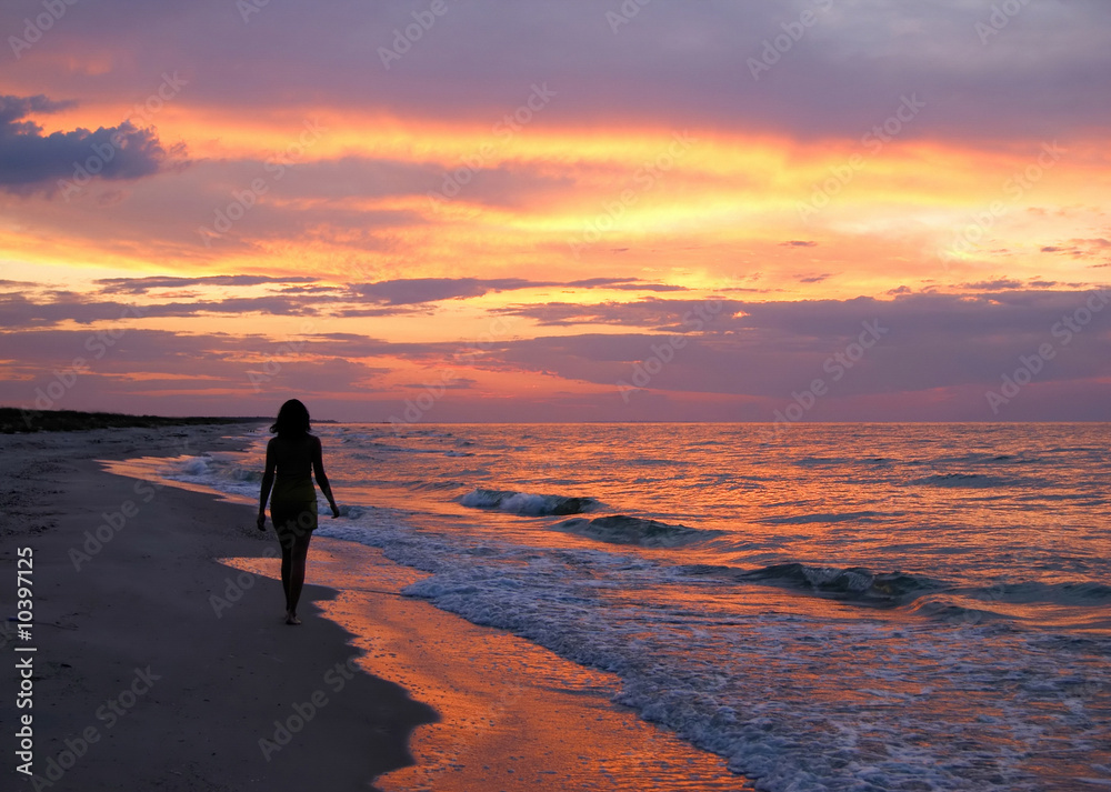 Beautiful young woman silhouette on sunset background