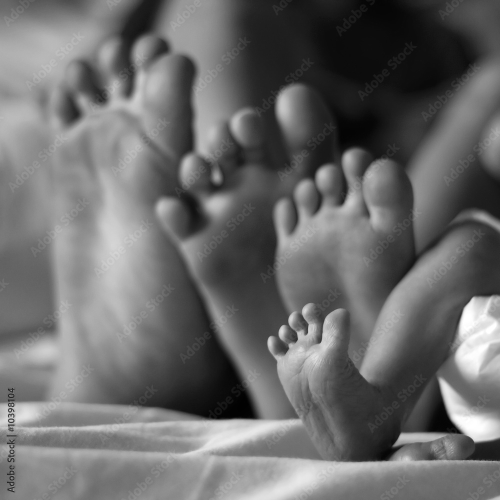 cute newborn foot with siblings feet behind her cute newborn foot with siblings feet behind her