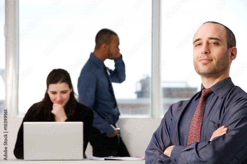 three business associates with a grey laptop three business associates with a grey laptop