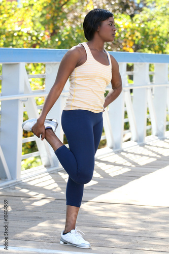 Beautiful African-American female exercising, stretching
