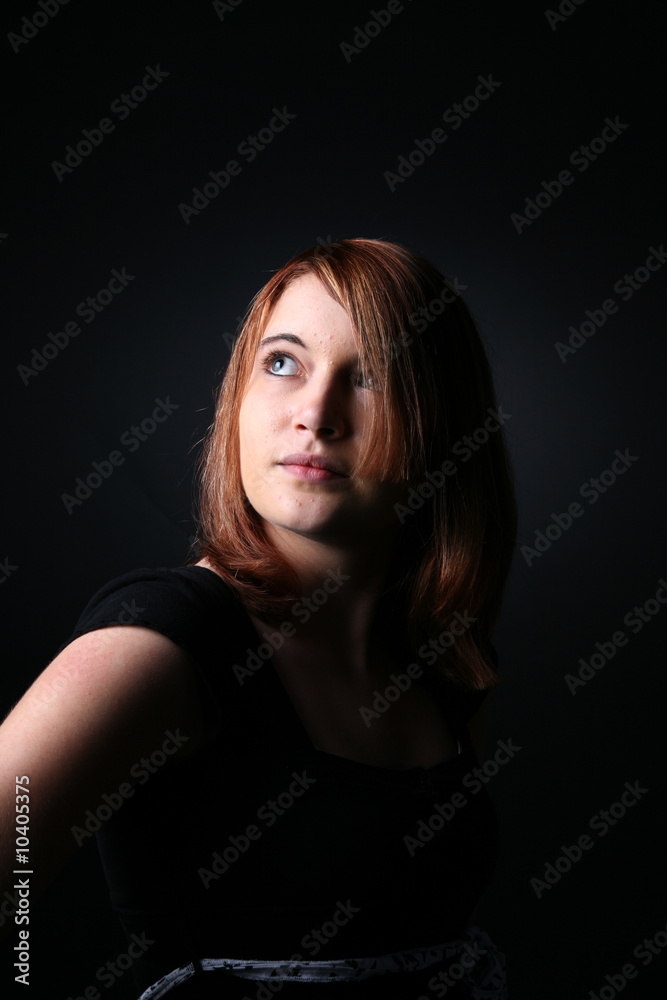 pretty teen with auburn hair looking up and away pretty teen with auburn hair looking up and away