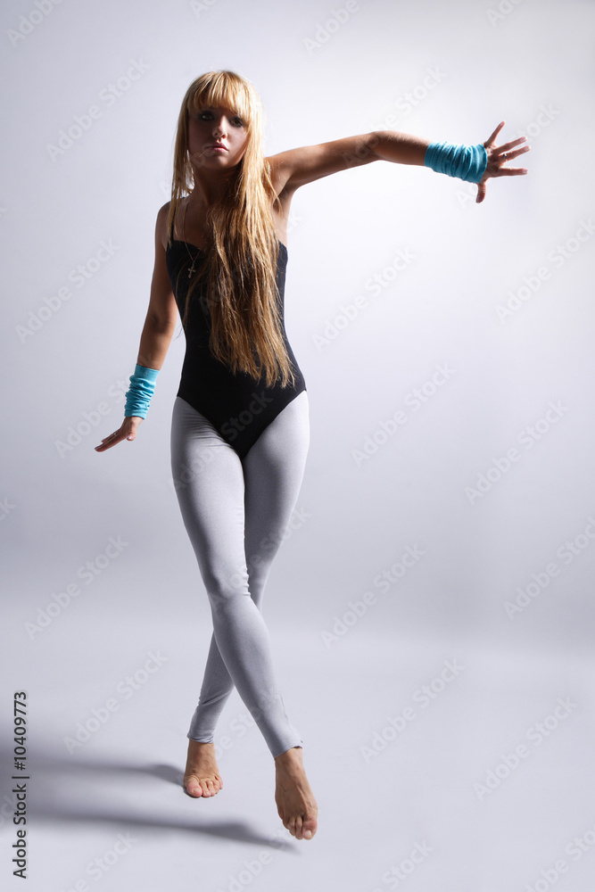 young beautiful dancer posing on grey