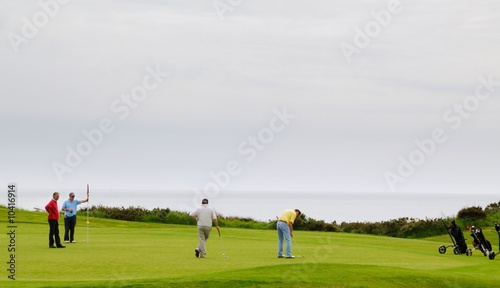 Golfeurs sur un green en bord de mer
