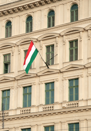 Hungarian flag against office building facade.