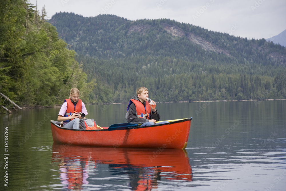 Girl and boy canoeing, Canada Girl and boy canoeing, Canada