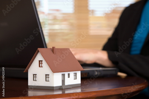 real estate concept with a house and laptop at the office