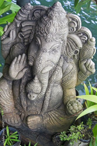 image of ganesh statue standing between plants