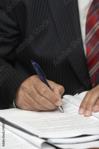 close up of businessman hands signing contract