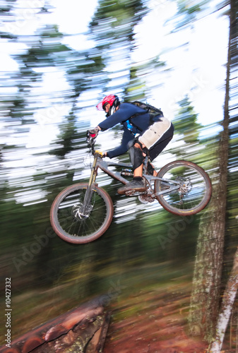 A skilled mountin biker leaps off of a jump.