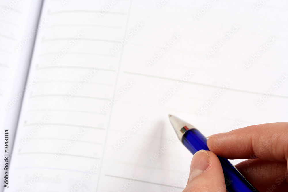 Close-up of woman hand writing in agenda Close-up of woman hand writing in agenda