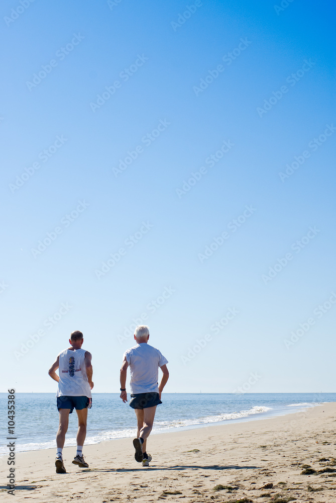 dos señores mayores corriendo en la playa