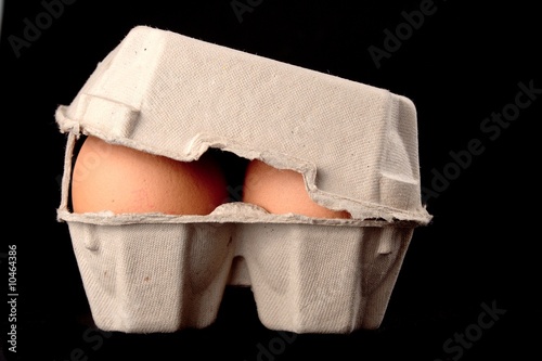 Eggs in paper box isolated on black background
