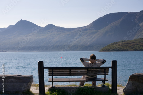 relaxed man sitting on the bank of lake