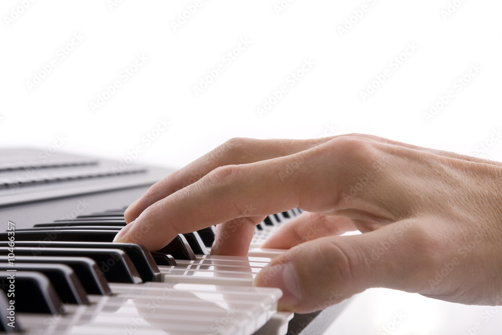 Fototapeta premium A musicians hand on a keyboard isolated on white