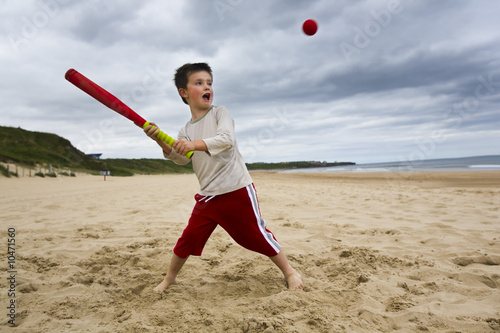 Photos Little boy playing baseball on beach