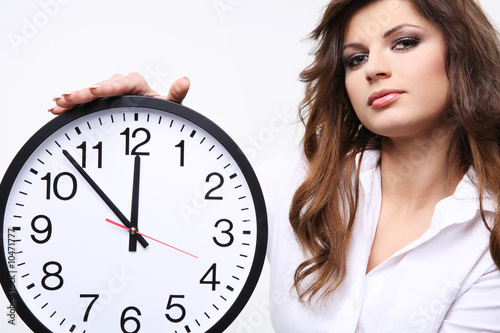 Beautiful young woman holding big clock.