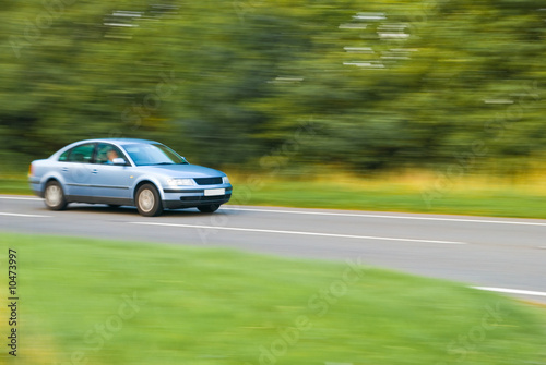 Car travelling down country lane, panned motion blur