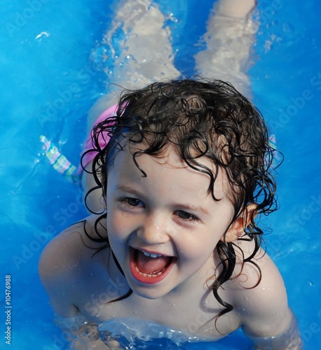 bimba che gioca in piscina photo