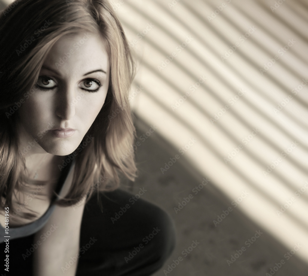 Fototapeta premium portrait of a serious young woman near window