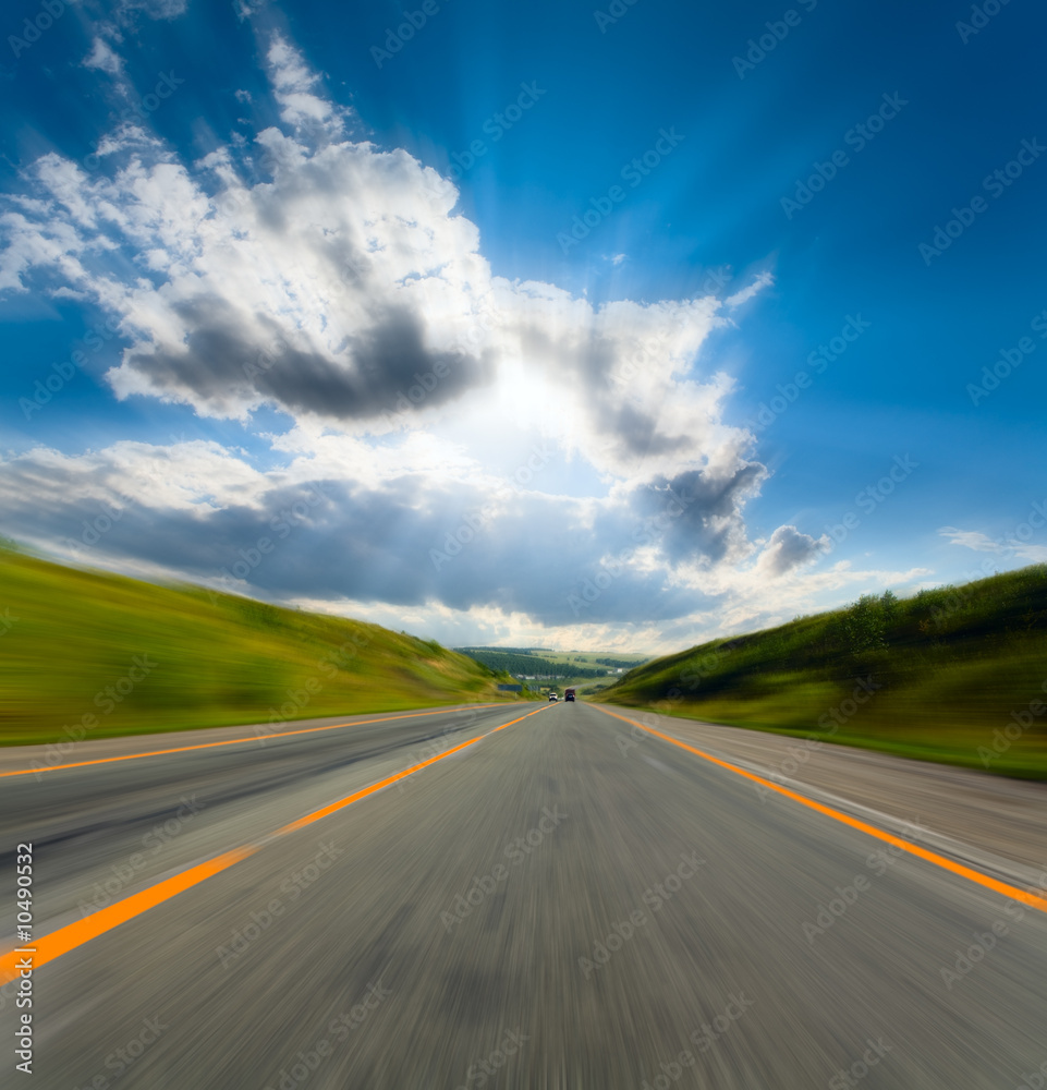 motion blurred road and cloudy blue sky