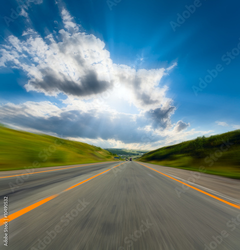 motion blurred road and cloudy blue sky
