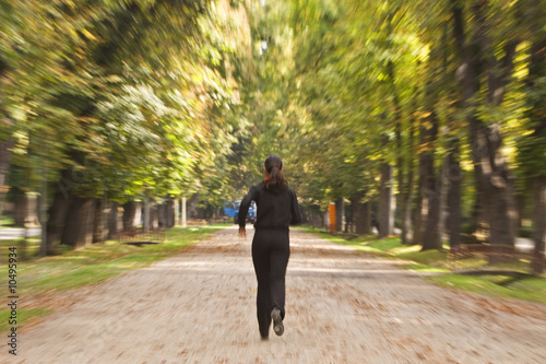 Zoom-in image of a woman running in an autumn park. © Provisualstock.com