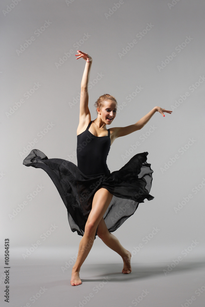 Naklejka premium young and beautiful ballerina posing on grey background