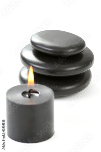black pebbles with candle isolated on white