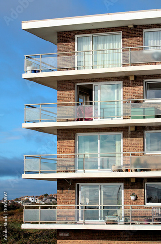 Old block of flats or apartments in England with sunny terraces