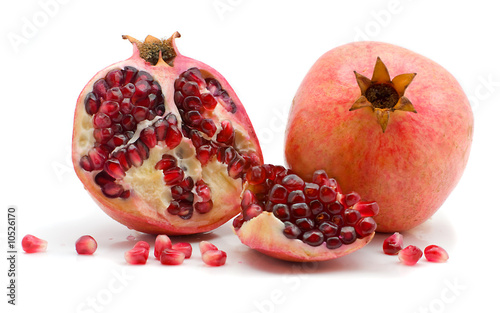 Half and scattered grains of a pomegranate on a white background