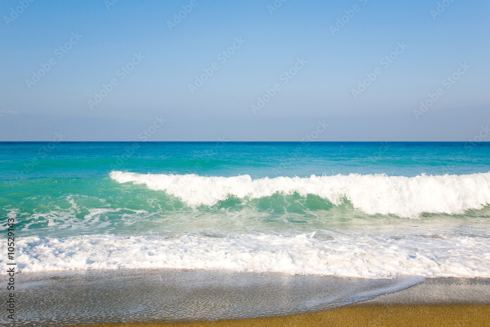 Scene of sky, sea, waves and sandy beach.