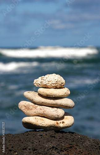 White coral rocks stacked by a meditating zen follower photo