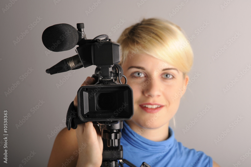junge blonde Frau mit einer Videokamera junge blonde Frau mit einer Videokamera