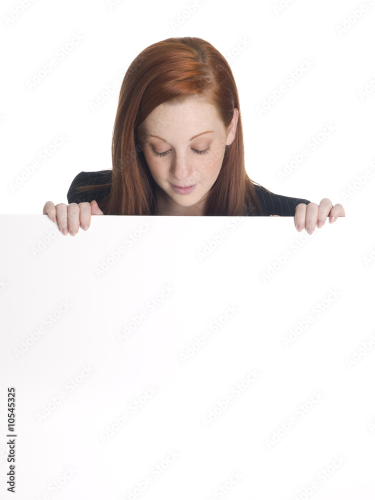 businesswoman looking over the edge of a blank white sign. businesswoman looking over the edge of a blank white sign.