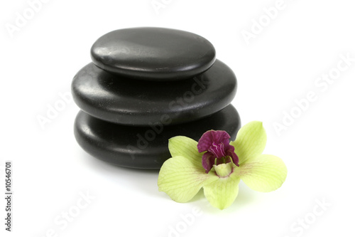 black pebbles with yellow orchid isolated on white