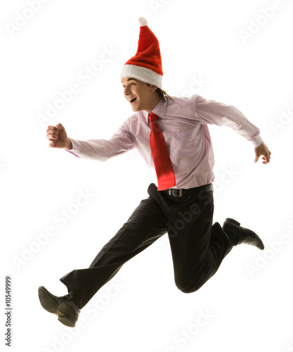 Excited businessman wearing sasnta cap in jump