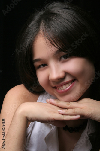 smiling girl with hands under the face