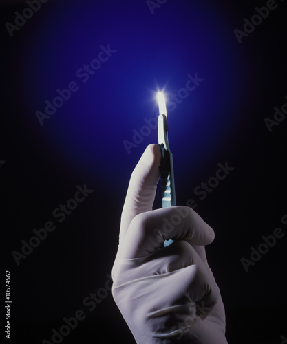 Photo a sharp scalpel in a surgeon's gloved hand