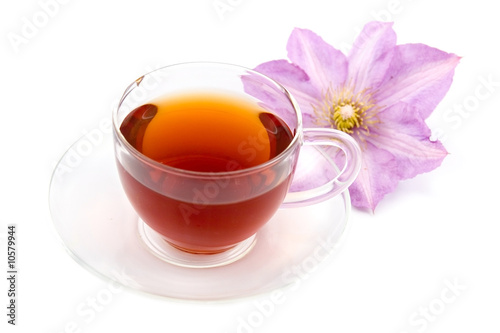 Transparent teacup with tea and flower