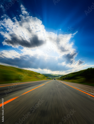motion blurred road and cloudy blue sky © gornist